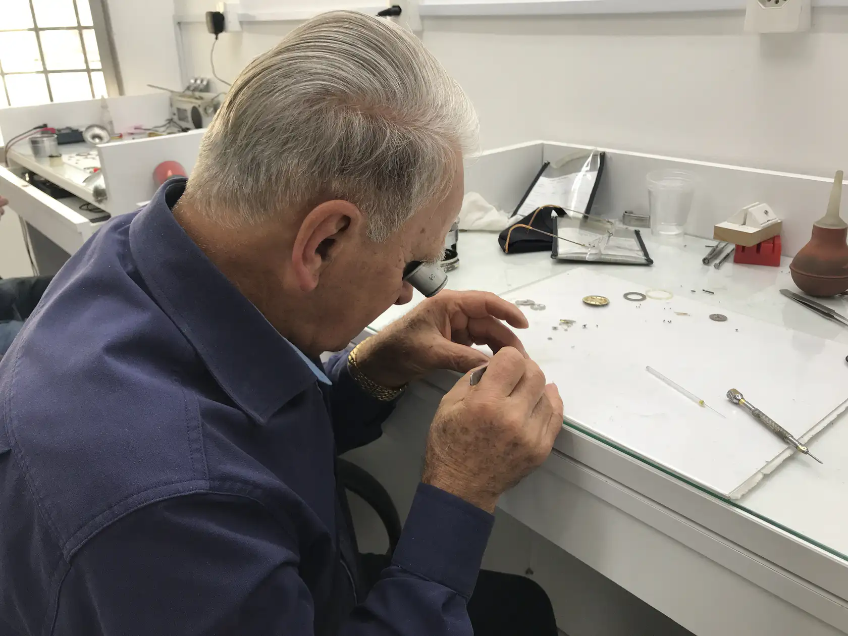 Foto do fundador Ivo Pioner consertando um relógi